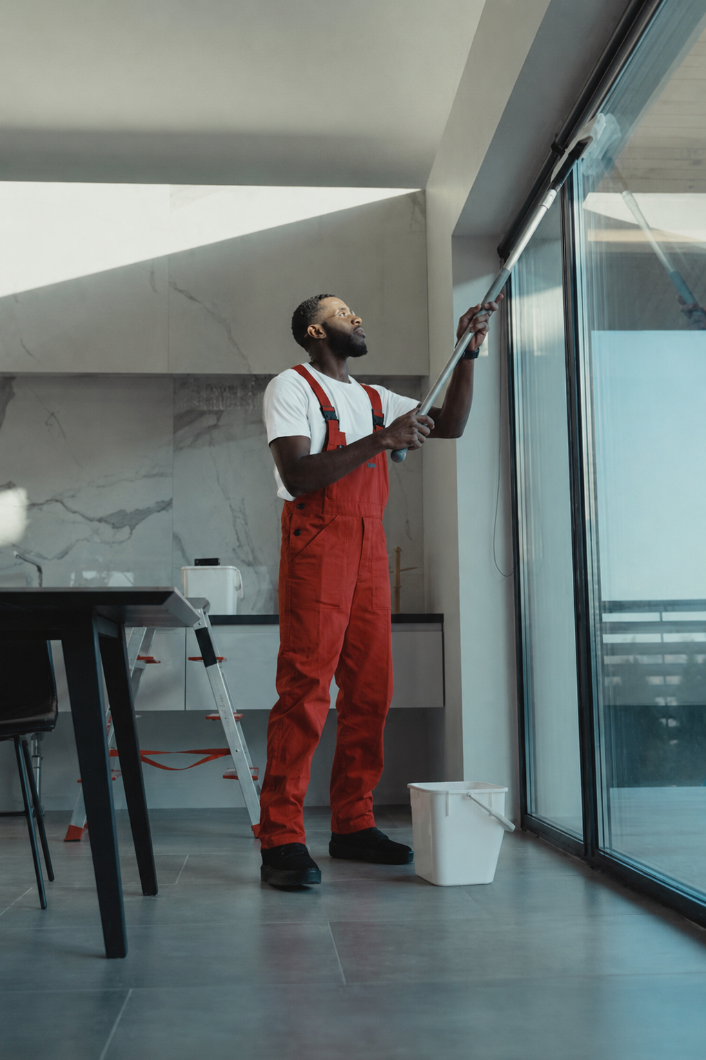 SkyPSI technician cleaning interior glass with an extension pole